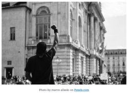 Person with a raised fist at a rally