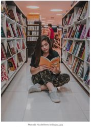 girl reading in library courtesy Nicole Berro on Pexels.com