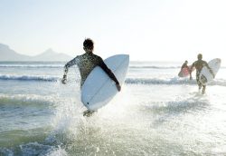 Surfers running out to the waves