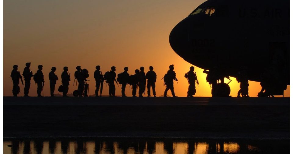 soldiers line up to board a plane